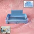 Plastic soap dish with drain slots and self-adhesive wall mount