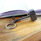 Stylish metal hammer keychain held in hand showing design