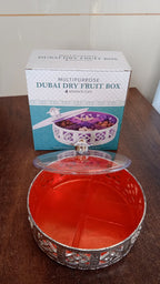 Round silver dry fruit box displayed for home serving on a table.
