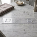 Close-up of transparent bathroom shelf with white hooks
