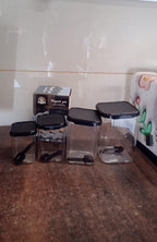 Four air tight plastic containers with included spoons and white lids for kitchen storage