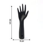 Black hand jewelry display stand placed on shelf for accessories