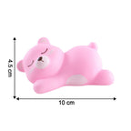 Portable sleeping bear night light held in hand demonstrating its compact size.
