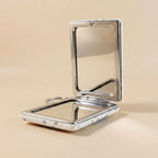 Foldable compact mirror keychain demonstrating dual-sided mirrors