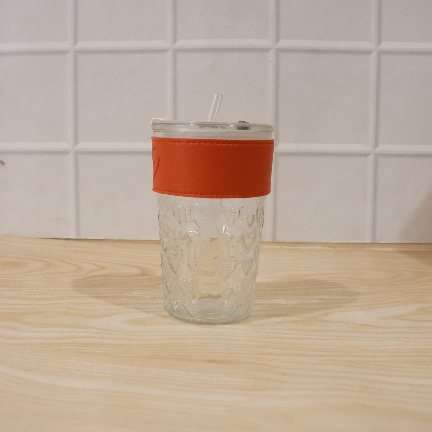 Hand holding glass tumbler with lid, perfect for daily hydration